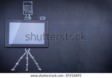 Tablet computer as photo camera on the blackboard with tripod and strobe drawn with chalk