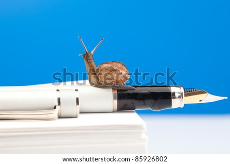 Cute snail on the fountain pen and pile of paper