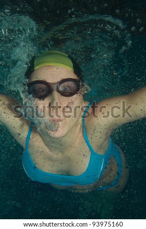 Woman swimmer underwater shoot in glasses and cap