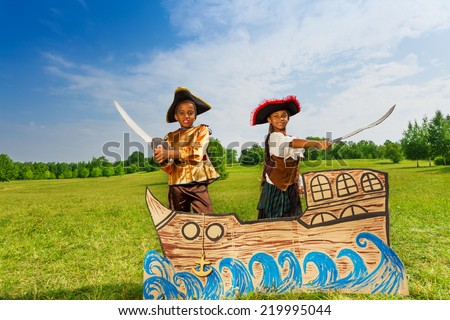 African boy, girl in pirates costumes with swords