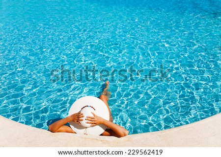Lady with white hat laying in the blue water
