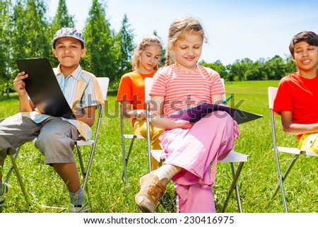 Drawing children sit on white chairs outside in summer