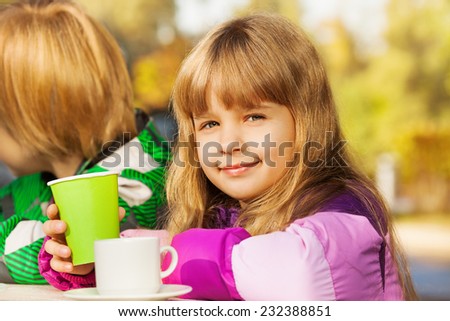Beautiful small blond girl with green cup