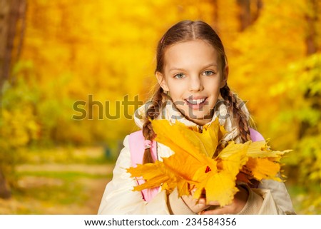 Portrait of girl with autumn yellow leaves bunch