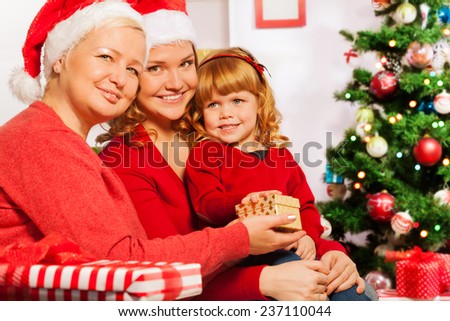 Granny and mother give presents to 3 years girl