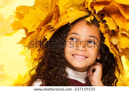 Smiling black girl wearing maple leaves crown