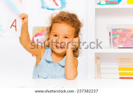 Cute little girl with letter card reading lesson