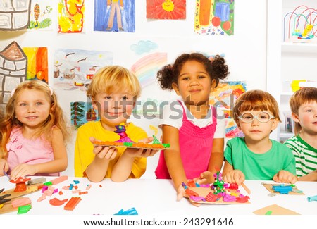 Happy kids with modeling clay in classroom