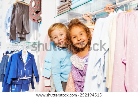 Amazed boy and girl play hide-and-seek in shop