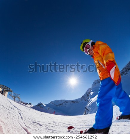 Fisheye view of smiling boy in ski mask skiing