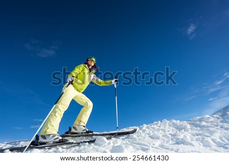 Young woman in mask holding ski poles and skiing