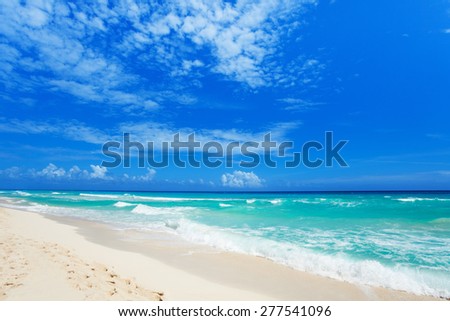 Nice summer beach with footsteps on white sand and beautiful waves