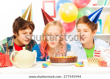 Beautiful teen girl blow cake on birthday party