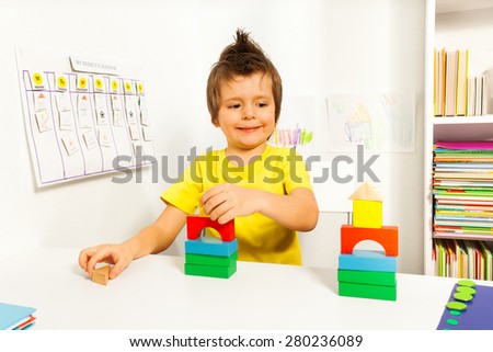 Smiling boy replicating example with color blocks