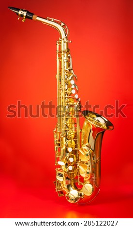 Alto saxophone in full length on red background