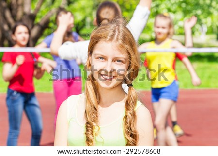 Portrait of teen girl with friends play volleyball