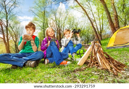Three children resting near the wooden bonfire