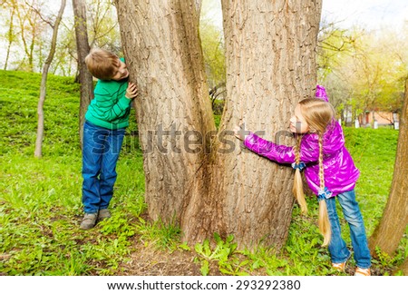 Boy and girl playing hide-and-seek in the forest