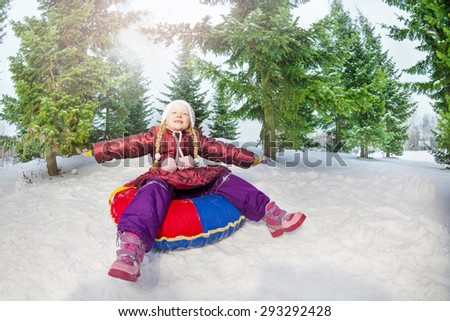 Girl sitting on snow tube relaxed in winter
