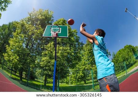 Arabian boy throws ball in basketball goal