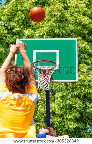 Boy throwing up the ball during basketball game