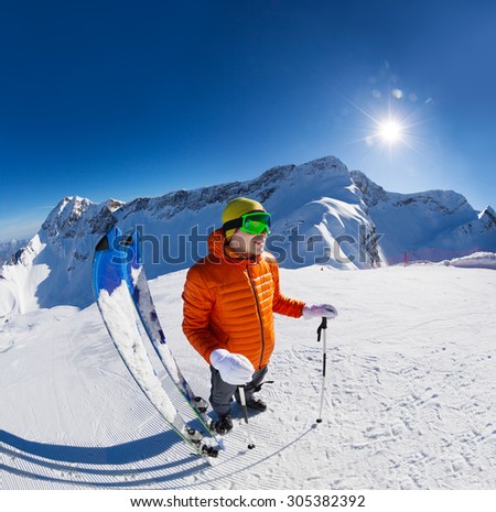 Guy standing with ski near in snow during sunny winter day on Krasnaya polyana ski resort with Caucasus mountains in Sochi, Russia