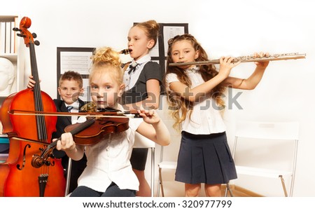 School children playing musical instruments together during their concert in school