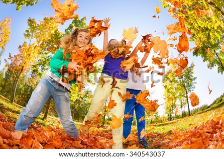Kids playing with thrown leaves in the forest