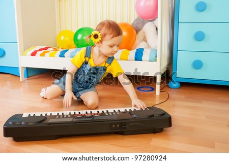 Girl playing piano sitting on the floor in bedroom