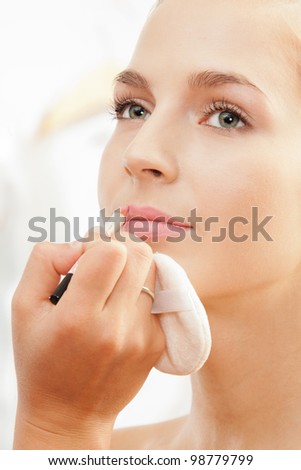 Close-up of makeup artist working - defining lips shape with lip pencil