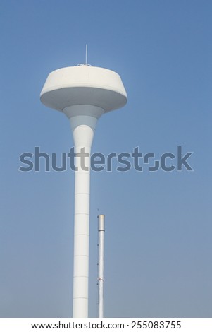 White tower water tank and smokestack on blue isolated.