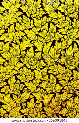 Golden flower pattern in traditional Thai style art painting on window of the temple.\
Native Thai style pattern on door temple.