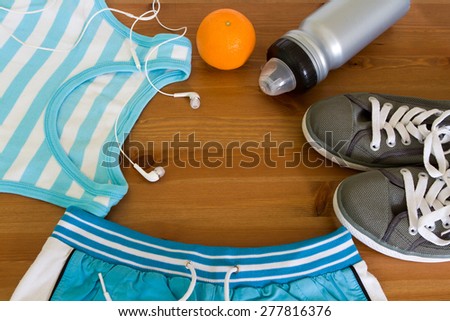 set for sports activities. Shirt, shorts, sports water bottle, orange, headphones, sneakers.  Preparing for the summer, diet, healthy lifestyle