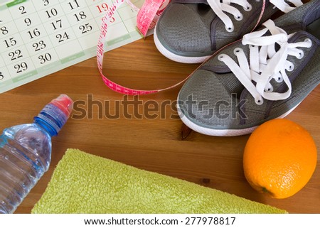 set for sports activities. Set for preparation for weight loss, running shoes, water, orange, calendar, towel