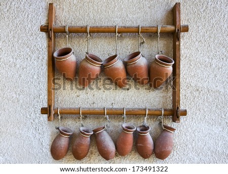 Hanging small terracotta jars against white wall
