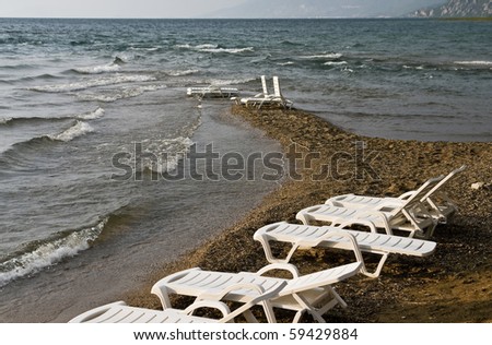 White lounge  chairs on a turbulent lake