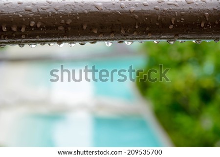 steel banister and raindrops with colorful abstract background
