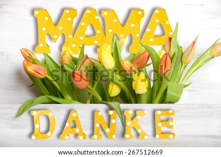 Thank you Mom, written with wooden letters on wood background with tulips