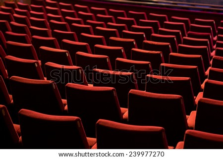 Empty theater with red chairs. Rear view.
