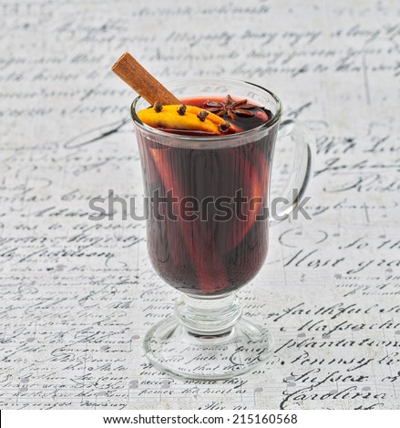 Cup of hot wine with spices on white background