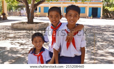VIETNAM - DECEMBER 14, 2012: unidentified Vietnamese school children in the school yard and school in the background.