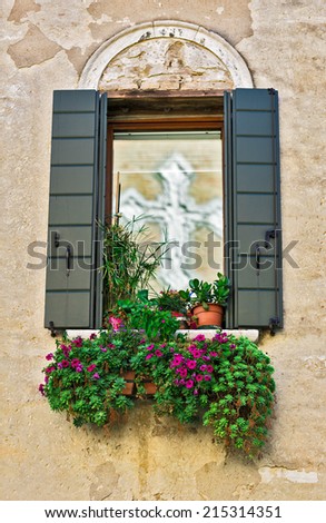 Window with a reflection of the cross beautified with flowers