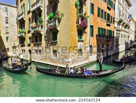 VENICE, ITALY - JUNE 26, 2014: Tourists travel on gondolas in Venice, Italy . Gondola trips are the most popular tourist activity in Venice.