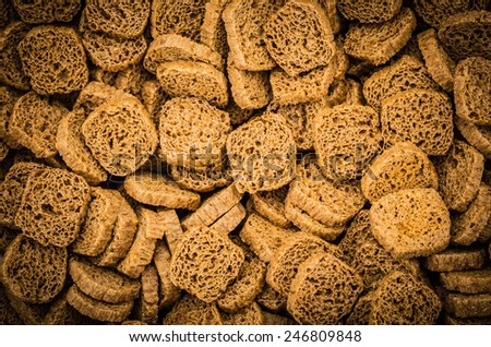 Many small dried rusks bread loaf toast biscuits as texture background. Diet food healthy nutrition.