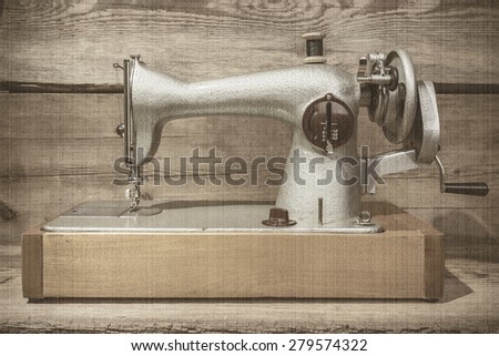 Retro sewing machine on a wooden background. Old style, sepia
