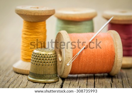 Vintage background with sewing tools and sewing kit. Scissors, bobbins, buttons on the old wooden background.
