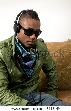 a young hip african-american male sits smugly with his retro 80\'s attire listing to music