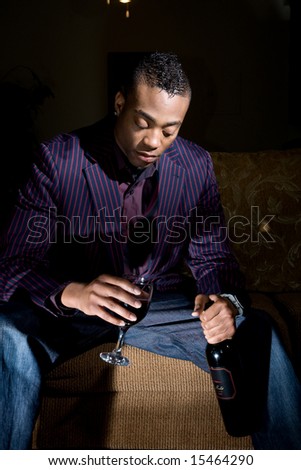 a fashionable, youthful african american contemplates drinking more wine