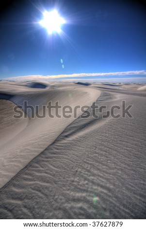 a line in the sand against bright blue sky and flaring sun