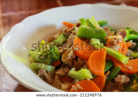 stir fried vegetables with pork in white dish./Fried vegetables.